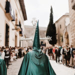 La Semana Santa de Baeza, una festividad de Interés Turístico 29 Foto del principio de una procesión, con los nazarenos vestidos de verde portando 2 ciriales y la cruz de guía